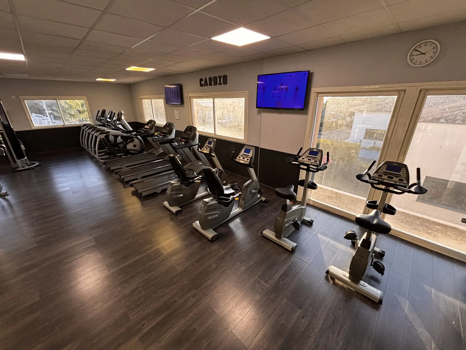 Rangée de tapis, vélos et appareils elliptiques dans l’espace cardio